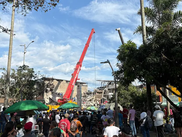 A red crane lifting debris from a collapsed building in Pereira, surrounded by emergency workers and onlookers.